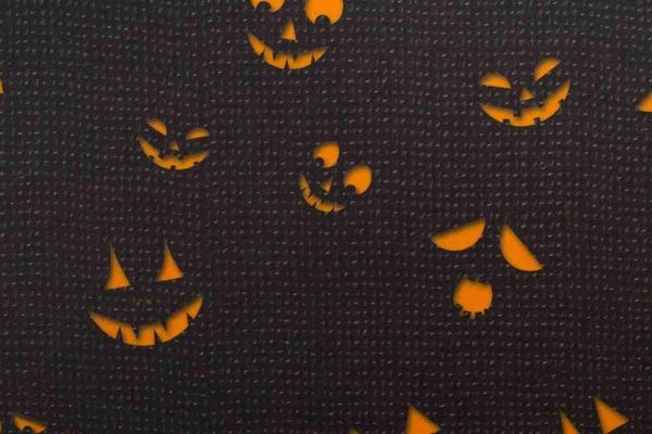 Jack-o-lantern eyes and mouths in orange on a black background