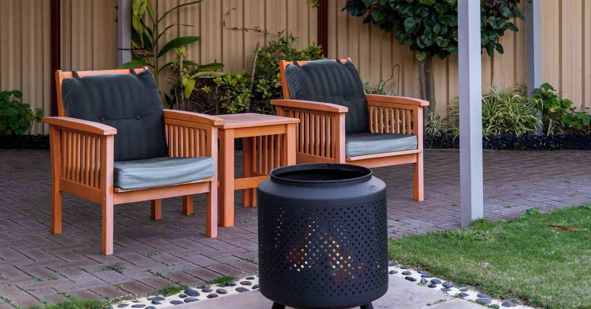 2 wooden chairs and a small firepit in a Scottsdale home backyard