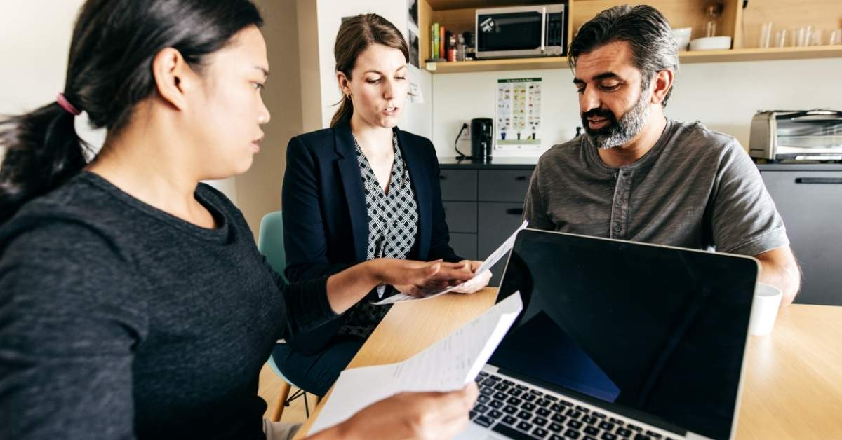 Three people reviewing the new rules for purchasing Scottsdale condos for sale