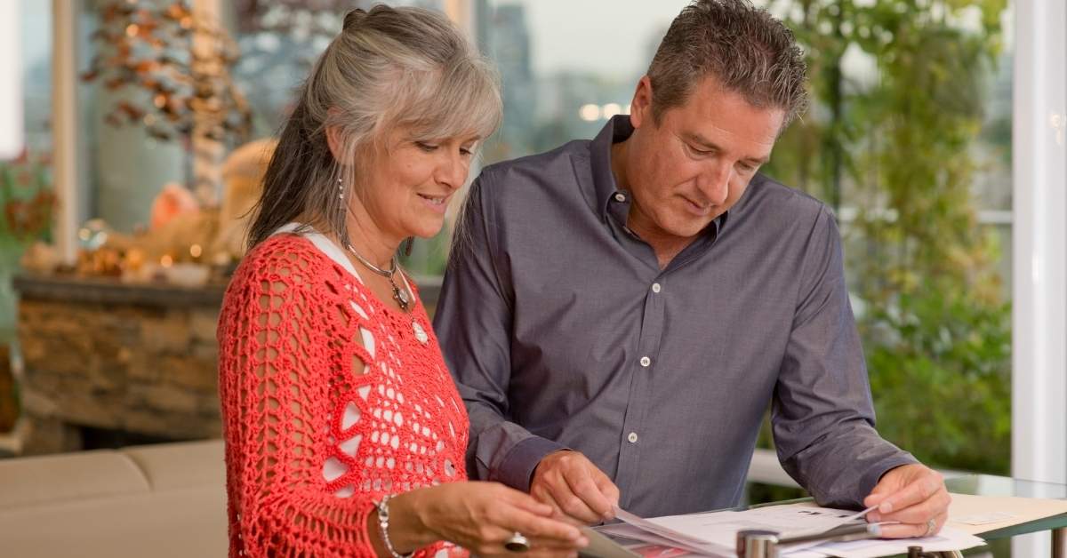 A middle aged couple looking through landscaping designs for their home for sale in Scottsdale