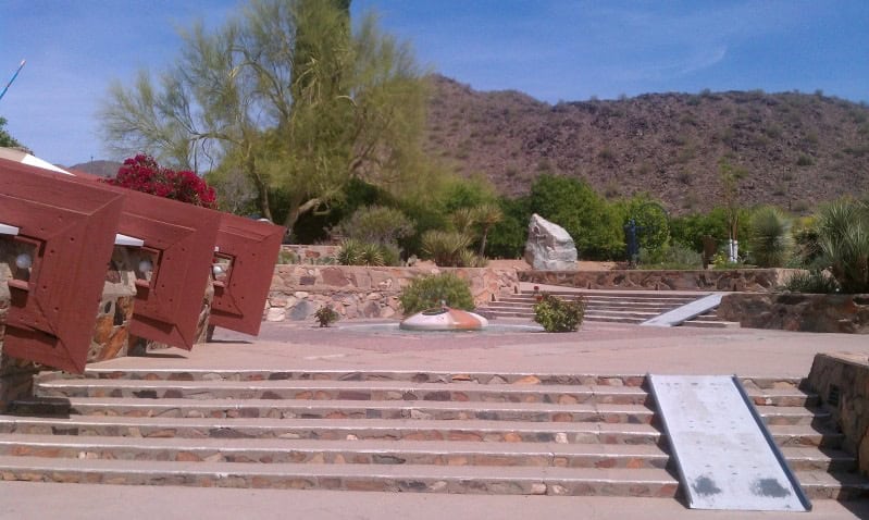 A slice of a building corner at Taliesin West, along with a fountain and a mountain view.