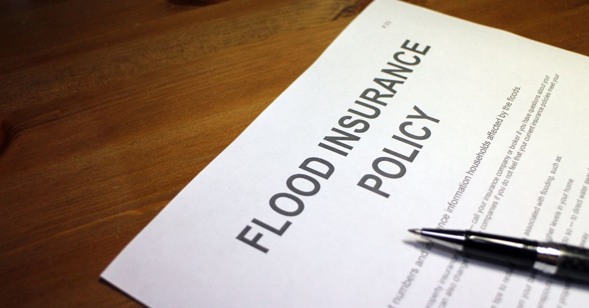 A Flood Insurance Policy on a desk with a pen on top