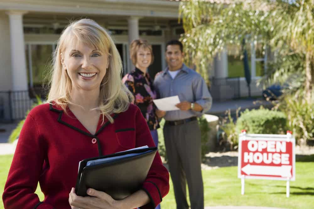 A female Scottsdale real estate agent in front of a house