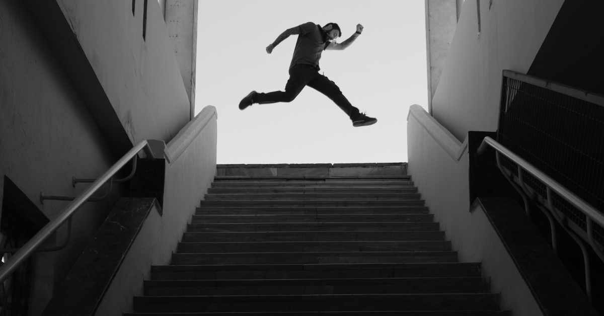 A black and white photo of a man taking a leap over stairs in a Scottsdale condo building