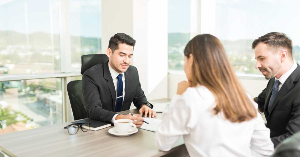 A loan officer at his desk with a couple helping them purchase a Scottsdale home for sale