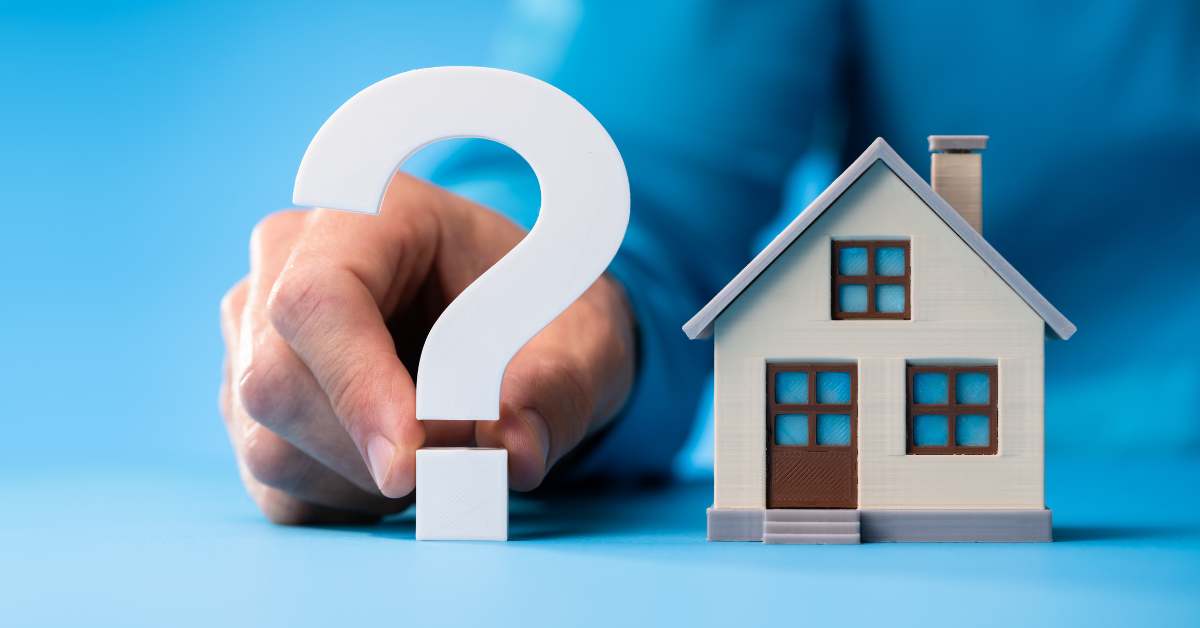 A big white question in front of a man's hand and a tiny Scottsdale home