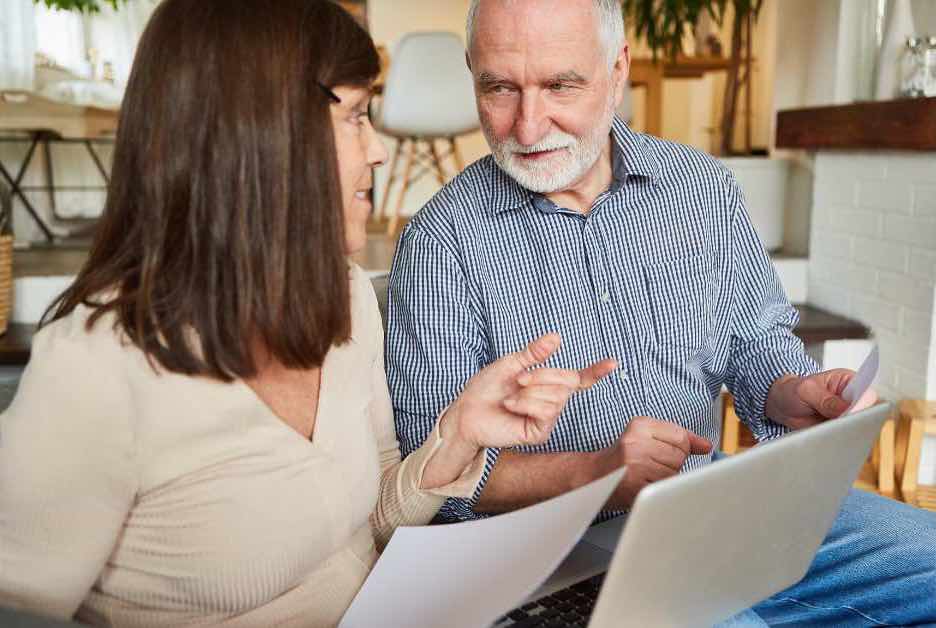 A retired couple looking at Scottsdale real estate online and talking about their finances
